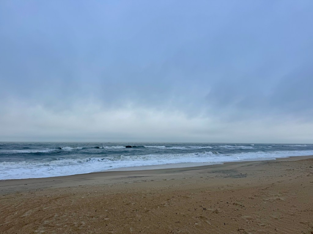 Beach with ocean, rainy clouds